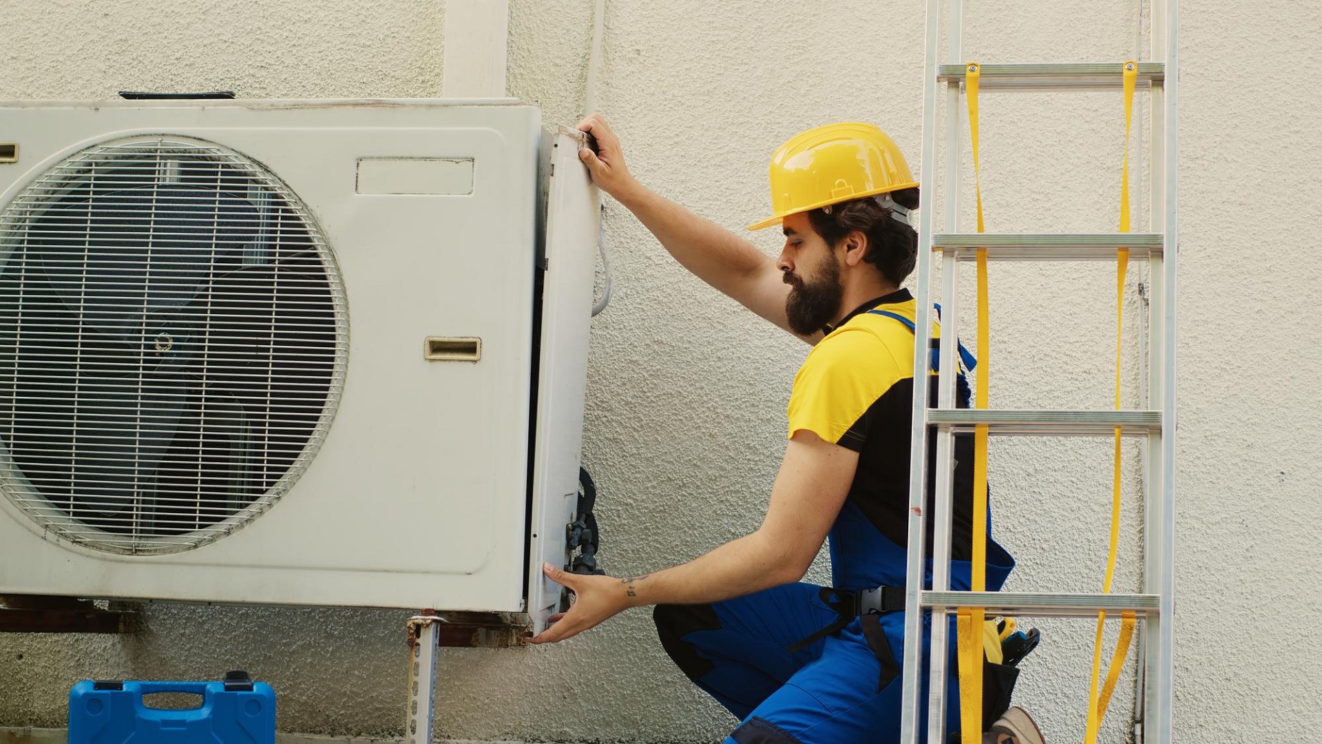 AC technician installing outdoor split unit air conditioner in Dammam